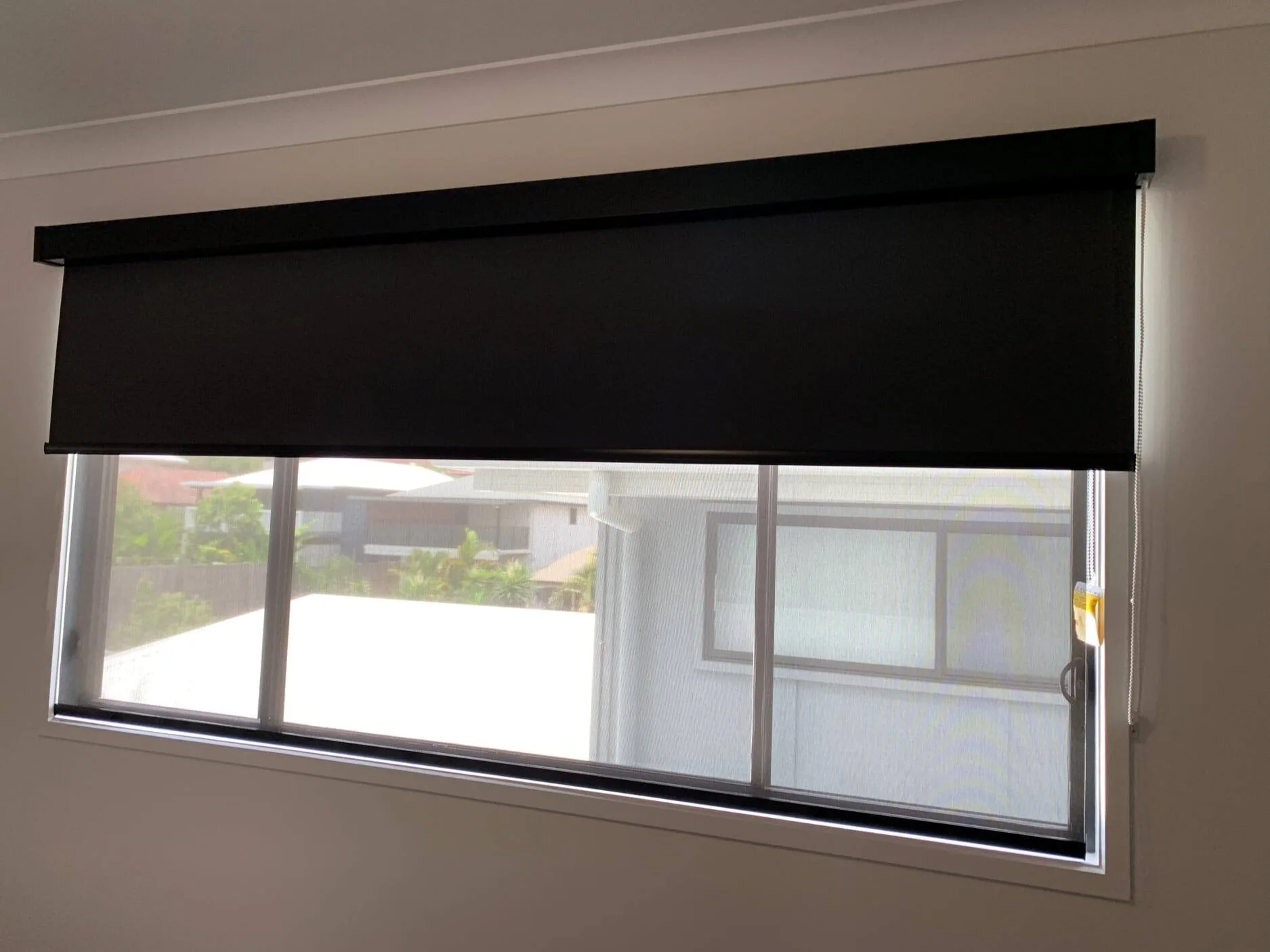 Blockout roller blind pulled down across a bedroom window