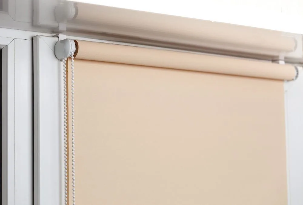 Beige blockout roller blind fitted to a white window frame