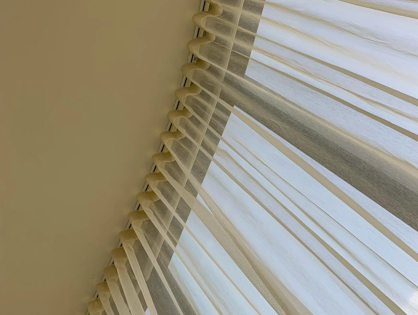 Close detail of a sheer curtain heading gathered in even folds below the track
