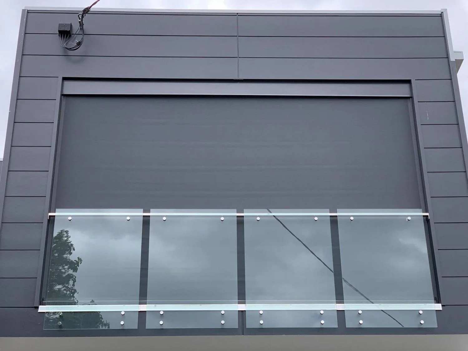Retractable outdoor awning fitted above a glass balustrade on a Brisbane home