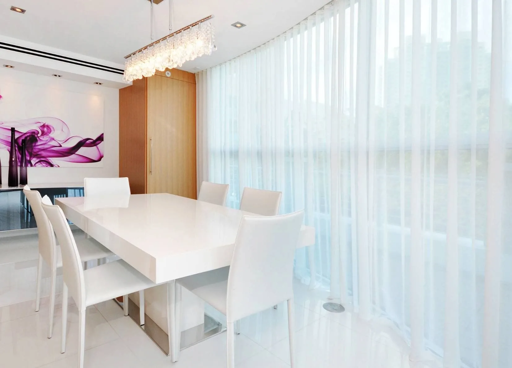 Sheer curtains running the full width of a light-filled dining room
