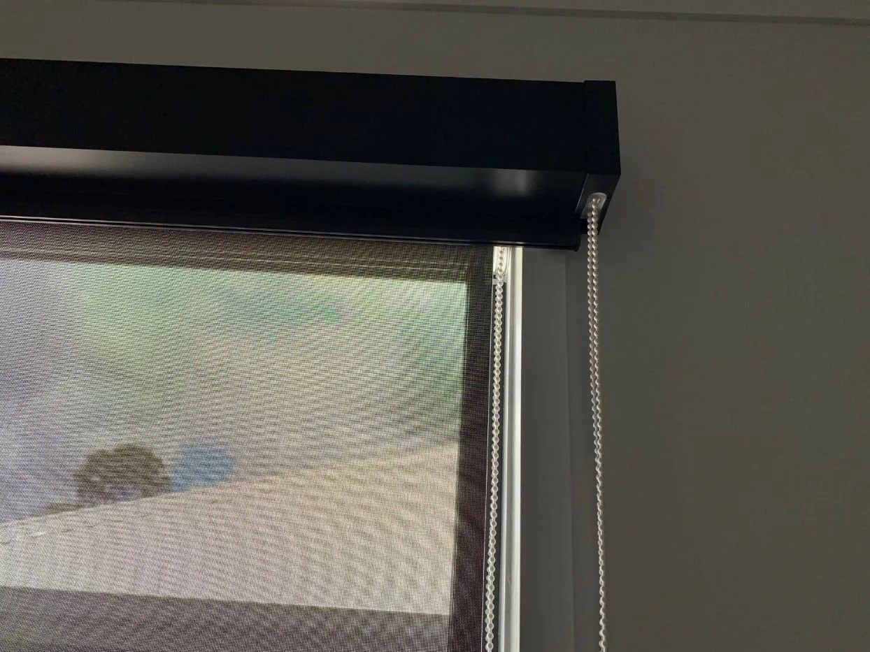 Close detail of a roller blind screen fabric against daylight