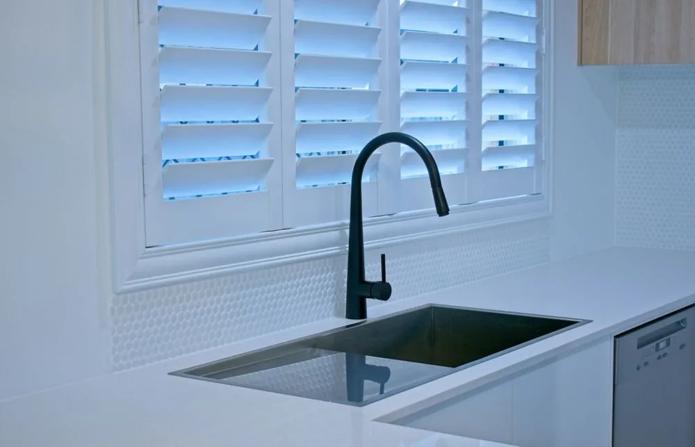 Plantation shutters fitted to a kitchen window above the bench