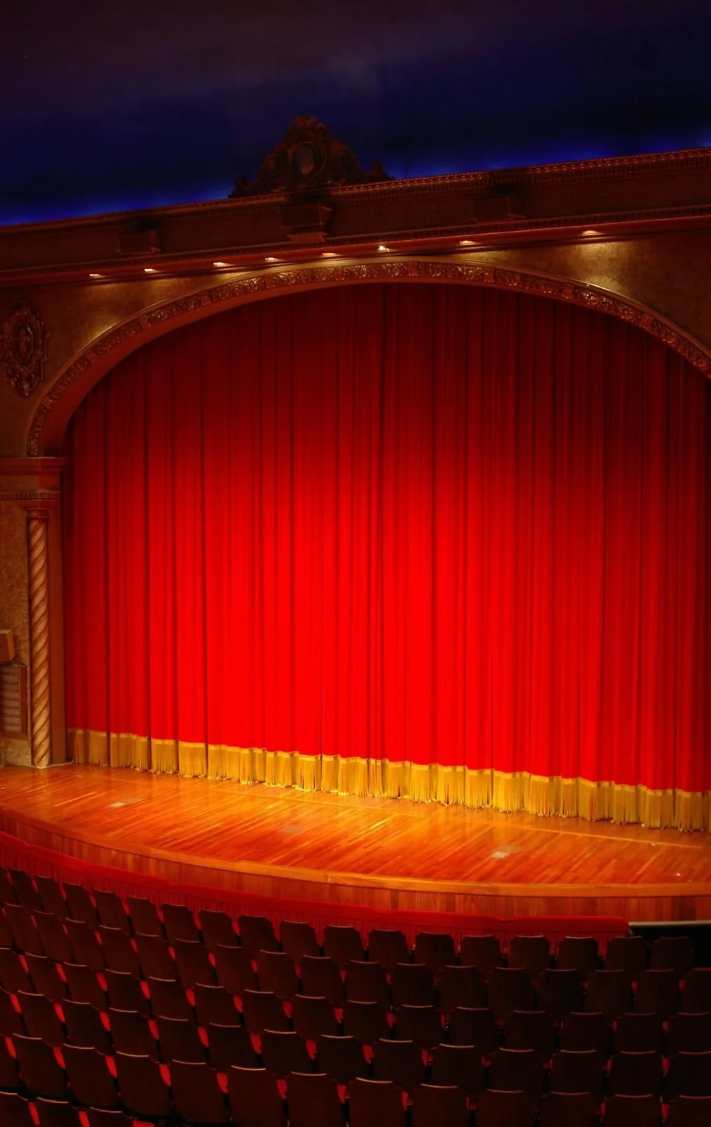 Theatre stage framed by drawn stage curtains